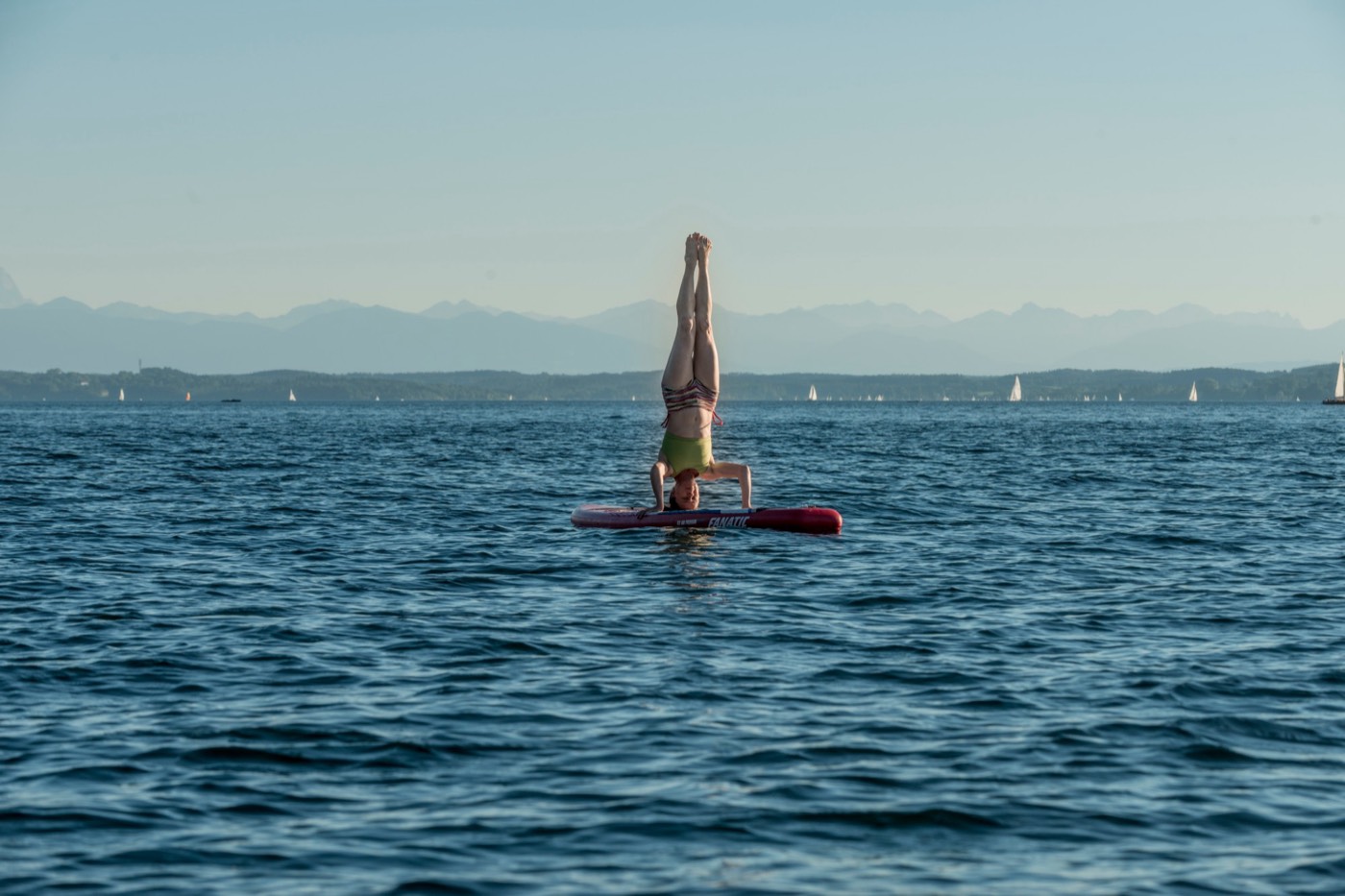 Karin im Kopfstand auf dem SUP-Board mitten im See