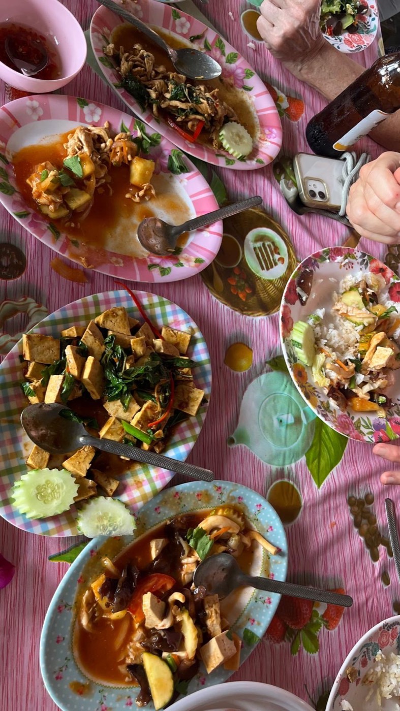 Bunte Teller mit Thai-Essen auf einem rosa Tisch