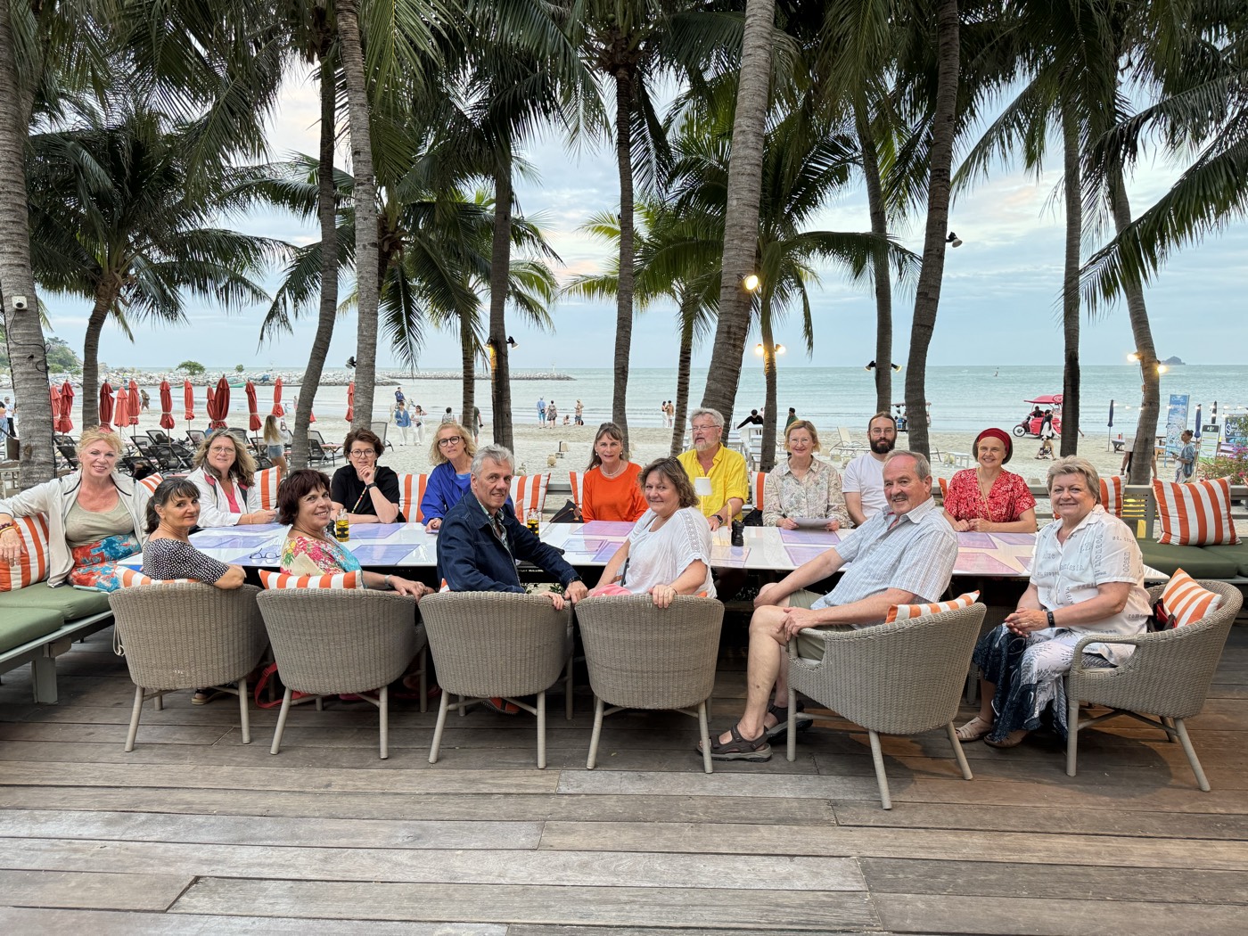 Festmahl der Gruppe an einer langen Tafel unter Palmen am Strand