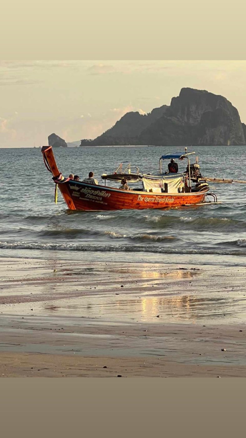 Longtail-Boot am Strand vor Felseninseln